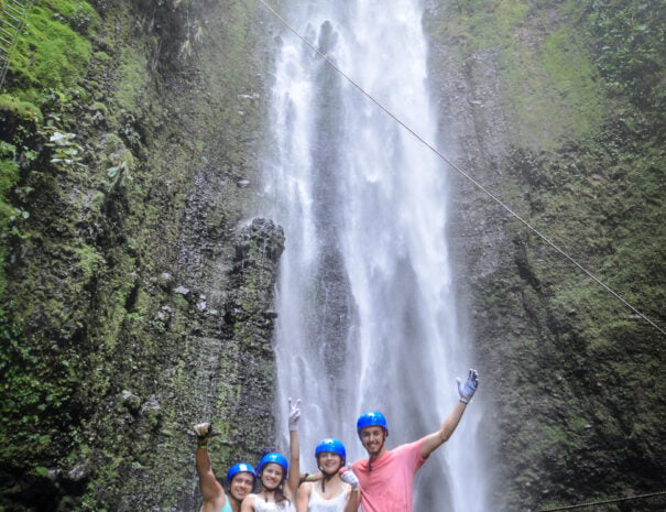 group of tourists in front of a waterfall