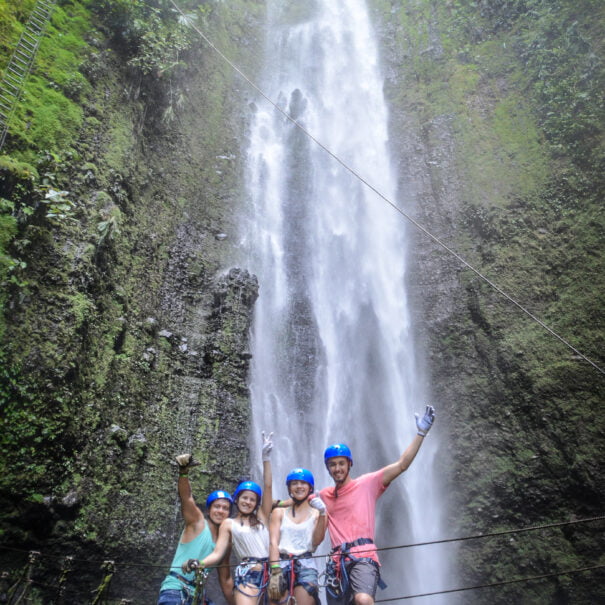 group of tourists in front of a waterfall